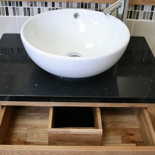 Above View of Round Curved White Ceramic Basin on Black Quartz Top Oak Vanity Unit Showing Drawer Storage