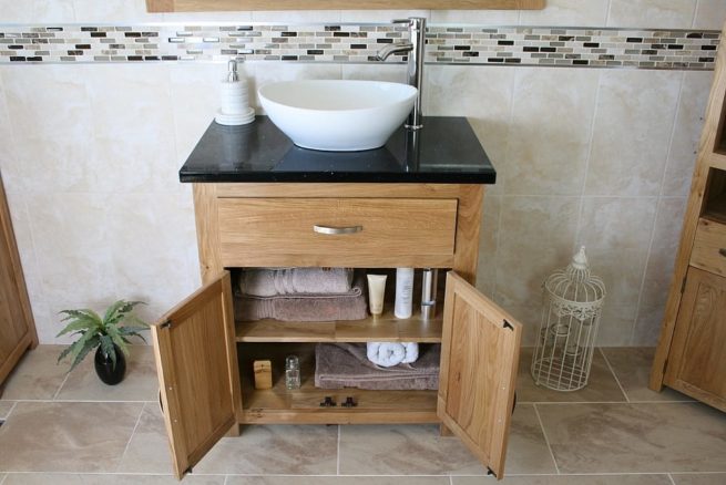 Front View of Oval White Ceramic Basin on Black Quartz Topped Oak Vanity Unit Showing Cupboard Storage