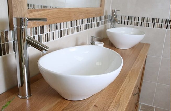 Close-Up Side View of Two White Ceramic Oval Basins on Large Oak Topped Vanity Unit