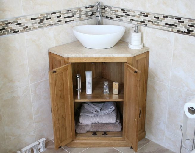 Oval Ceramic Wash Basin on Travertine Top Vanity Unit in Corner Showing Storage