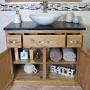 Front View of White Oval Marble Basin on Black Quartz Top Vanity Unit with Opened Doors