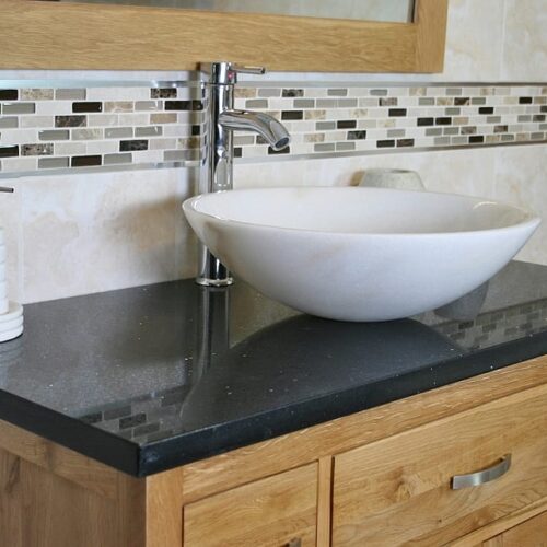 Close Up Side View of Black Quartz Top Vanity Unit & White Marble Basin