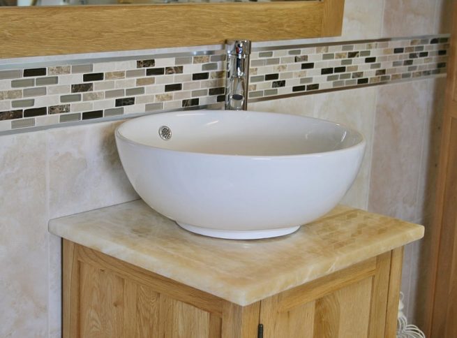 Closeup Side View of Round Curved White Ceramic Basin on Onyx Top Vanity Unit