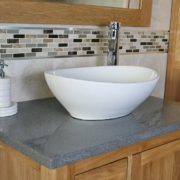 Close Up View of Oval White Ceramic Basin on Grey Quartz Top Vanity Unit