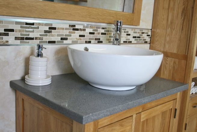 Side Closeup of Round Curved White Ceramic Basin on Grey Quartz Top Vanity Unit