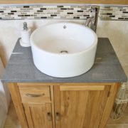 Above Close Up of Round White Ceramic Basin on Grey Quartz Top Vanity Unit